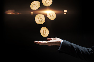 Image showing close up of businessman hand with bitcoins