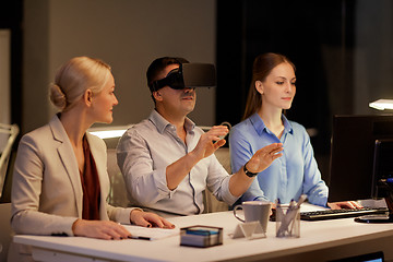 Image showing business team with computer working late at office