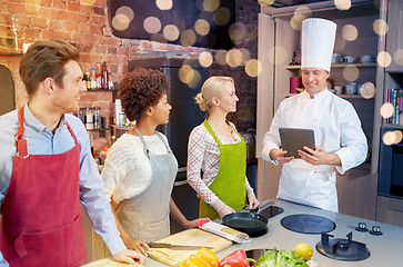 Image showing happy friends with tablet pc in kitchen