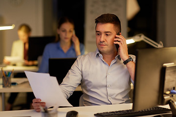 Image showing businessman calling on sartphone at night office