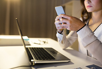 Image showing businesswoman with smartphone and laptop at office