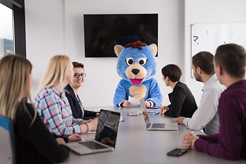 Image showing boss dresed as bear having fun with business people in trendy of