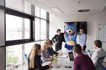 Image showing boss dresed as bear having fun with business people in trendy of