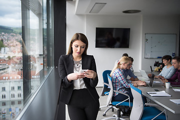 Image showing Business Girl Standing In A Modern Building Near The Window With