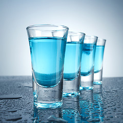 Image showing Vodka glass with ice on blue background