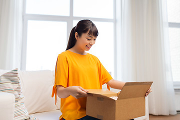 Image showing happy asian young woman with parcel box at home