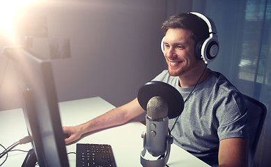 Image showing man in headset playing computer video game at home