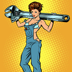 Image showing sexy woman in work overalls with a wrench