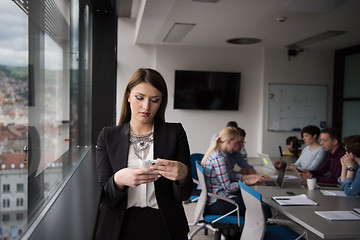 Image showing Business Girl Standing In A Modern Building Near The Window With