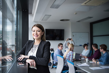 Image showing Elegant Woman Using Mobile Phone by window in office building