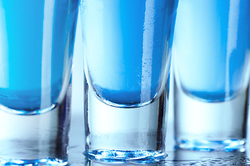 Image showing Vodka glass with ice on blue background