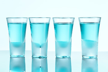 Image showing Vodka glass with ice on blue background