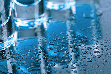 Image showing Vodka glass with ice on blue background