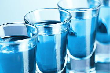 Image showing Vodka glass with ice on blue background