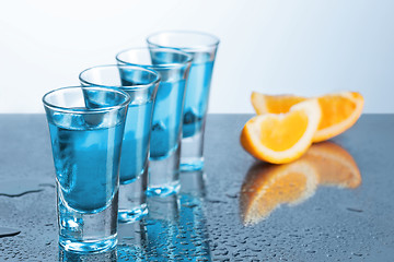 Image showing Vodka glass with ice on blue background