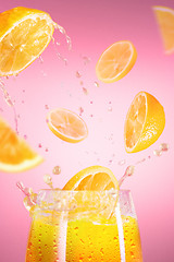Image showing Fresh lemons falling in juice with lot of huge splashes