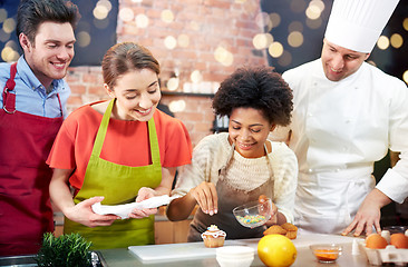 Image showing happy friends and chef cook baking in kitchen