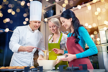 Image showing happy women and chef cook baking in kitchen