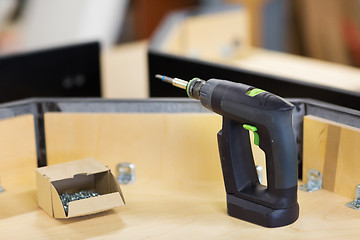 Image showing screwdriver with screws and furniture at workshop