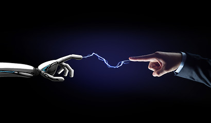 Image showing robot and human hand connected by lightning