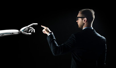 Image showing robot and human hand flash light over black