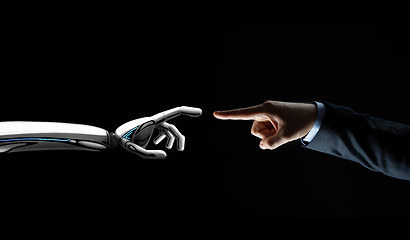 Image showing robot and human hand connecting fingers