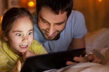 Image showing family with tablet pc in bed at night at home