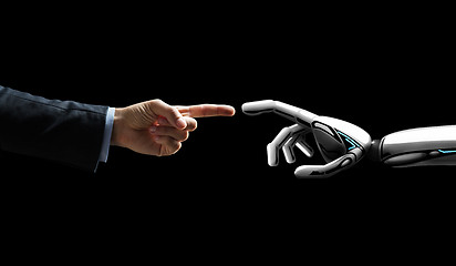 Image showing robot and human hand connecting fingers