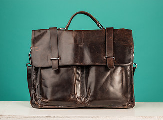 Image showing A vintage leather briefcase on a blue background