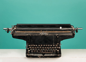 Image showing Retro old typewriter with paper on wooden table