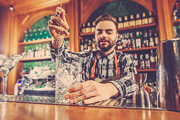 Image showing Barman making an alcoholic cocktail at the bar counter on the bar background