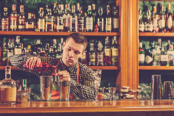 Image showing Barman making an alcoholic cocktail at the bar counter on the bar background