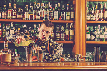 Image showing Barman making an alcoholic cocktail at the bar counter on the bar background