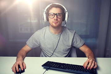 Image showing man in headset playing computer video game at home