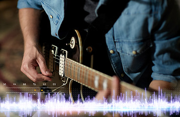 Image showing close up of man playing guitar at studio rehearsal