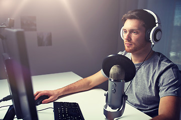 Image showing man in headset playing computer video game at home