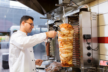 Image showing chef slicing doner meat from spit at kebab shop