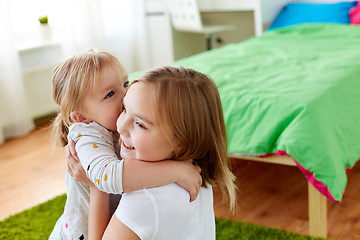 Image showing happy little girls or sisters hugging at home