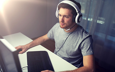 Image showing man in headset playing computer video game at home