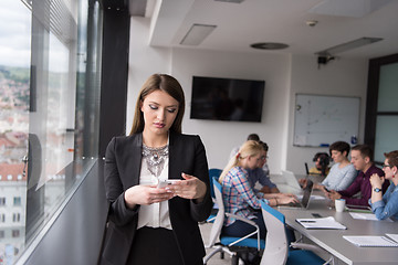 Image showing Business Girl Standing In A Modern Building Near The Window With