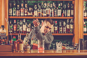 Image showing Barman making an alcoholic cocktail at the bar counter on the bar background