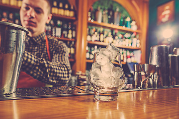 Image showing Barman making an alcoholic cocktail at the bar counter on the bar background