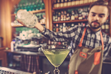 Image showing Barman making an alcoholic cocktail at the bar counter on the bar background