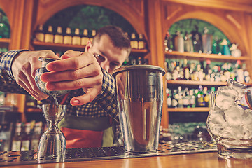 Image showing Barman making an alcoholic cocktail at the bar counter on the bar background