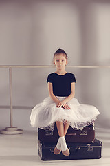 Image showing The little girl as balerina dancer sitting at studio