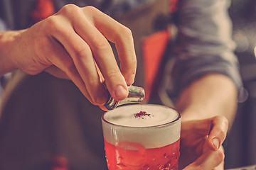 Image showing Barman making an alcoholic cocktail at the bar counter on the bar background