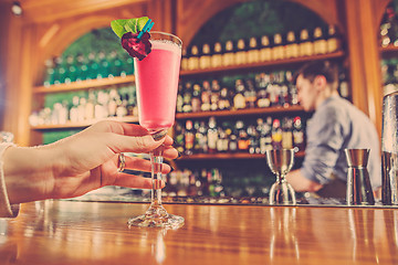 Image showing The girl is holding in his hand a glass of alcoholic beverage