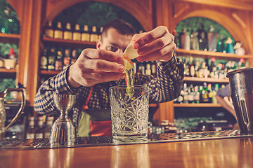 Image showing Barman making an alcoholic cocktail at the bar counter on the bar background