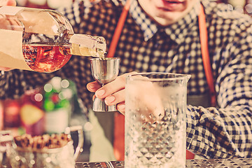 Image showing Barman making an alcoholic cocktail at the bar counter on the bar background