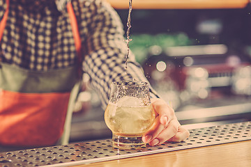 Image showing Barman making an alcoholic cocktail at the bar counter on the bar background